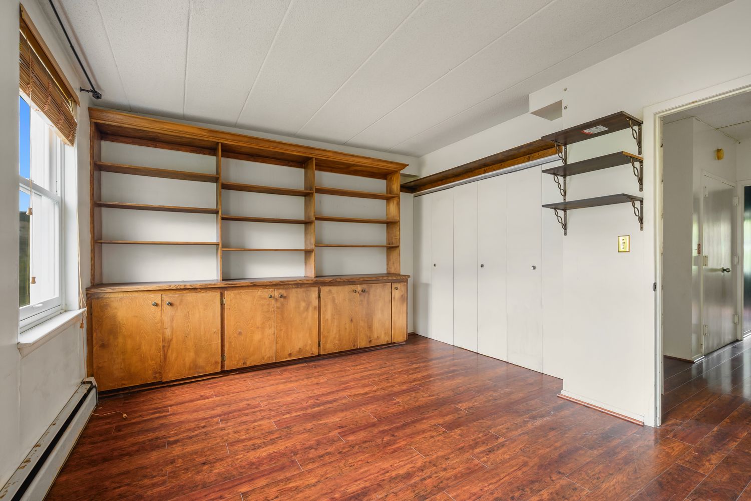 2560 Frederick Douglass Boulevard, Unit D Manhattan, NY 10030 - Photo 8 of 12 a view of an empty room with wooden floor and a window