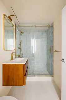 a bathroom with a sink mirror and shower