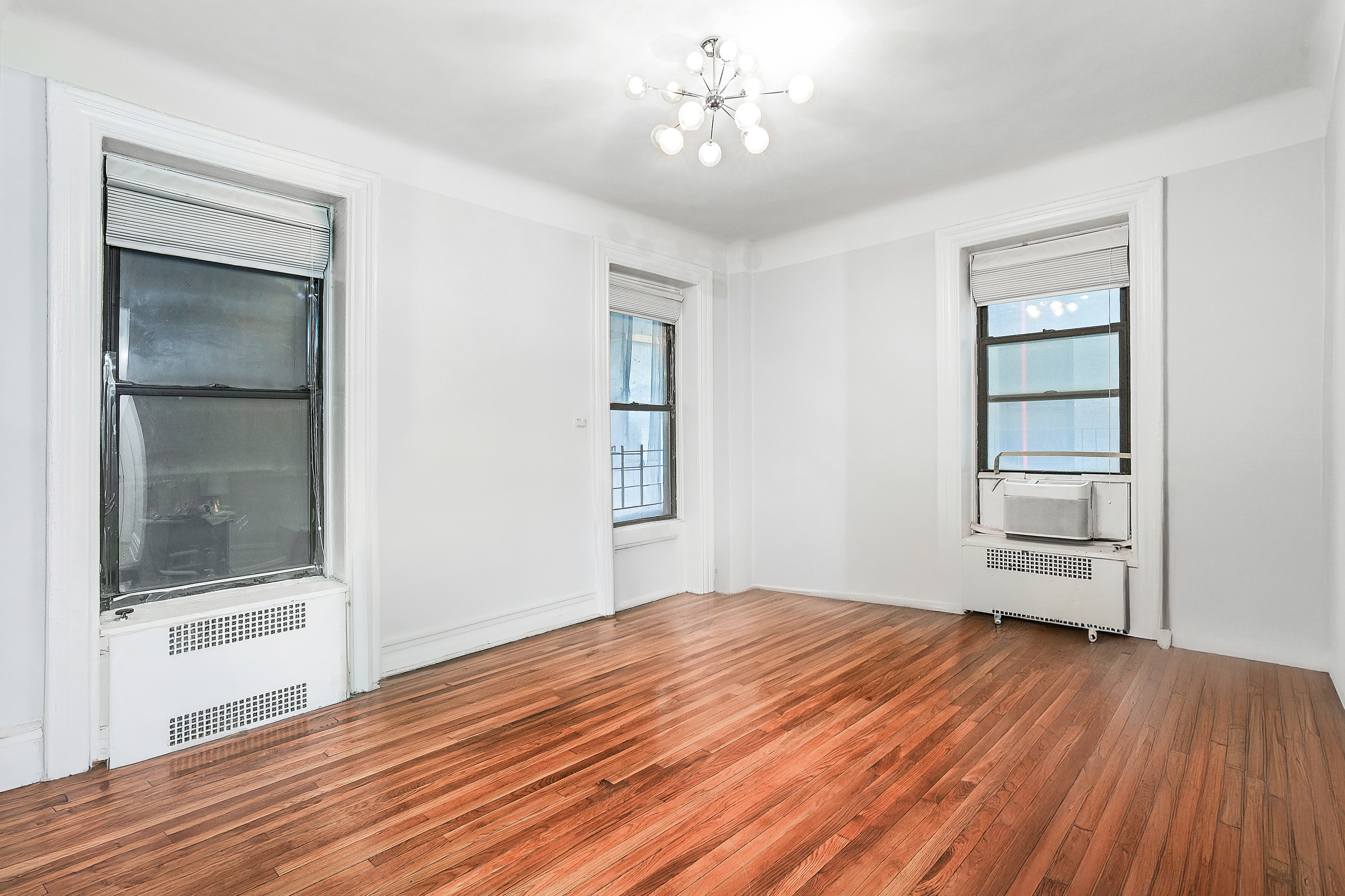 205 West 54th Street, Unit 3A Manhattan, NY 10019 - Photo 2 of 14 a view of empty room with wooden floor and fan