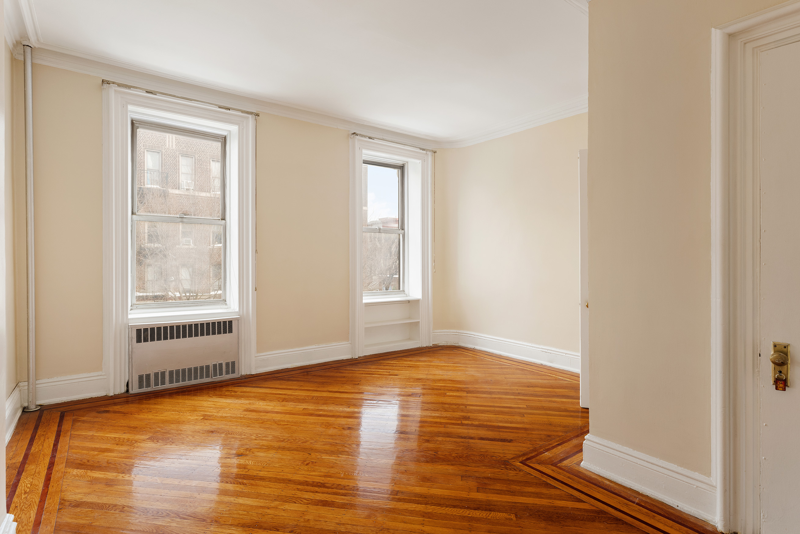 116 Brooklyn Avenue Brooklyn, NY 11216 - Photo 13 of 21 a view of an empty room with wooden floor and a window