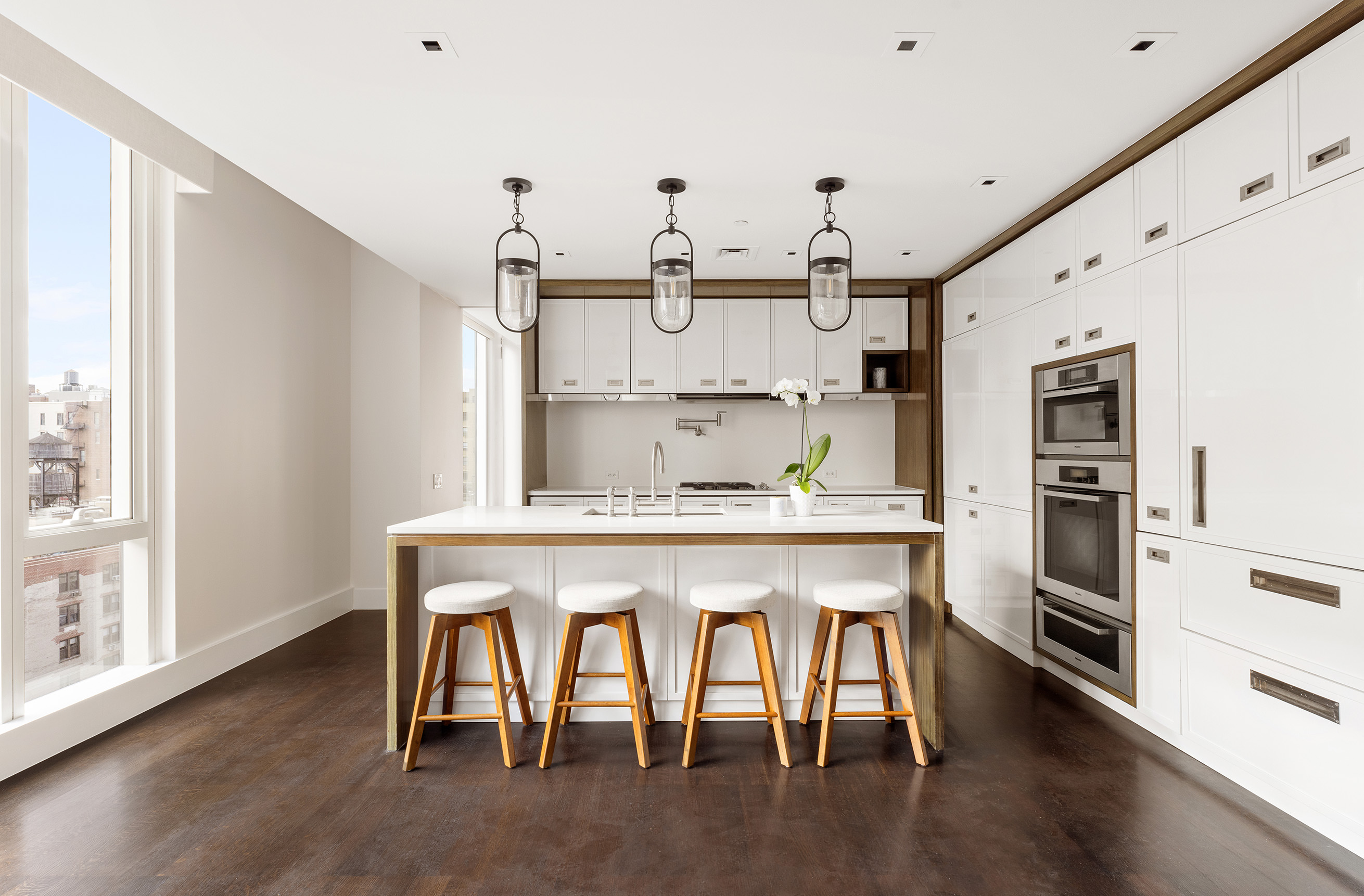 151 East 85th Street, Unit 14A Manhattan, NY 10028 - Photo 5 of 14 a kitchen with white cabinets and stainless steel appliances