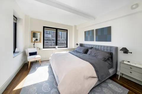 a spacious bedroom with a bed and a large window