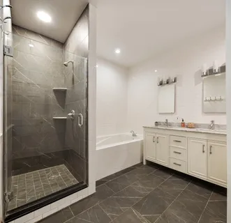 a bathroom with a bathtub shower sink mirror and toilet
