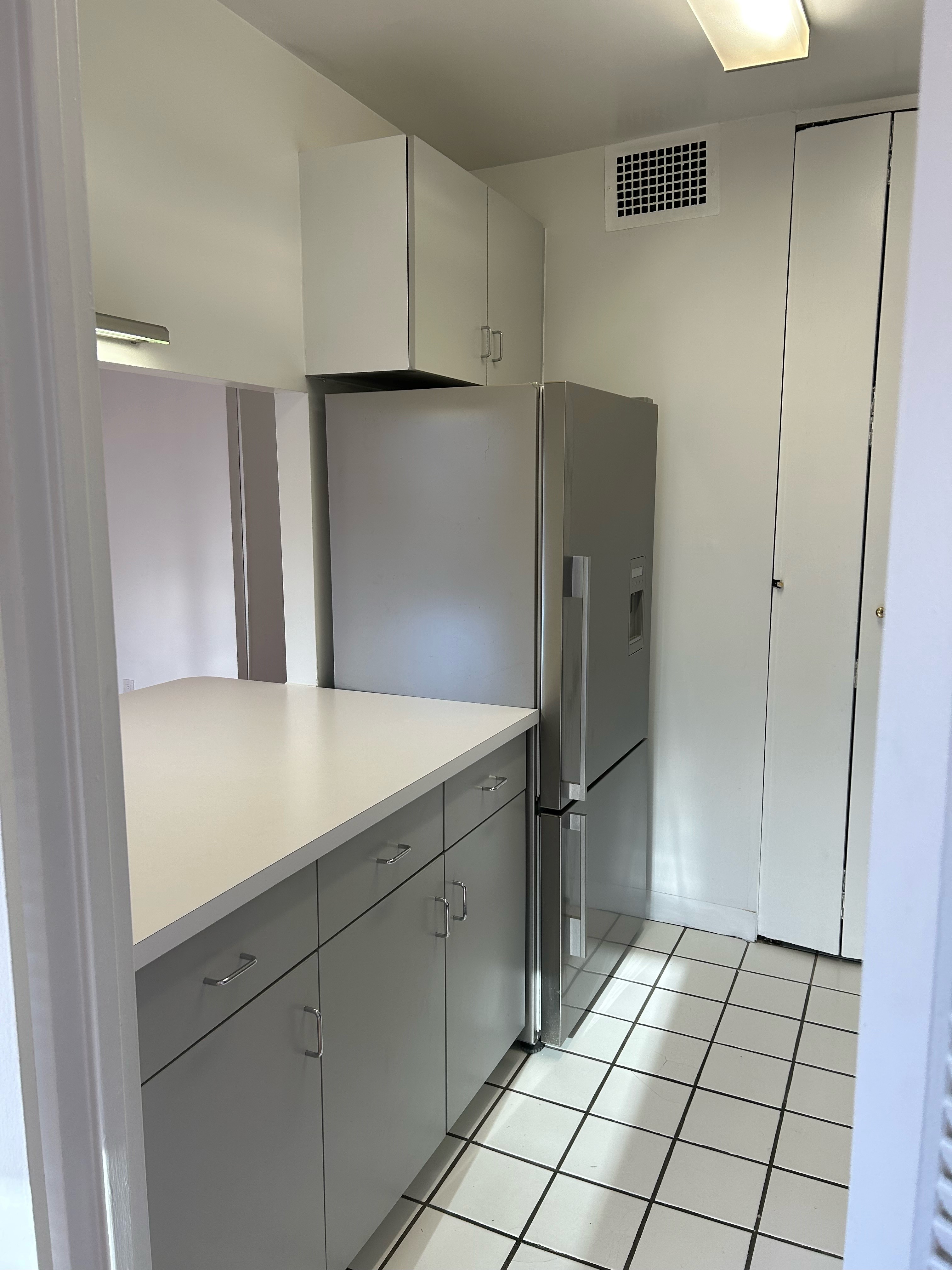 400 East 54th Street, Unit 18E Manhattan, NY 10022 - Photo 11 of 22 a kitchen with a refrigerator and cabinets