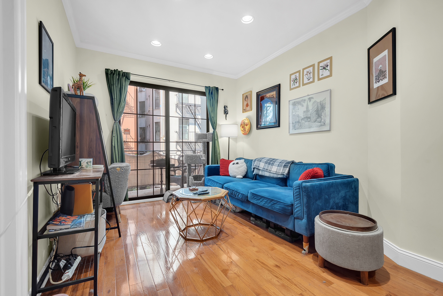 111 West 113th Street, Unit 3B Manhattan, NY 10026 - Photo 1 of 7 a living room with furniture and a flat screen tv