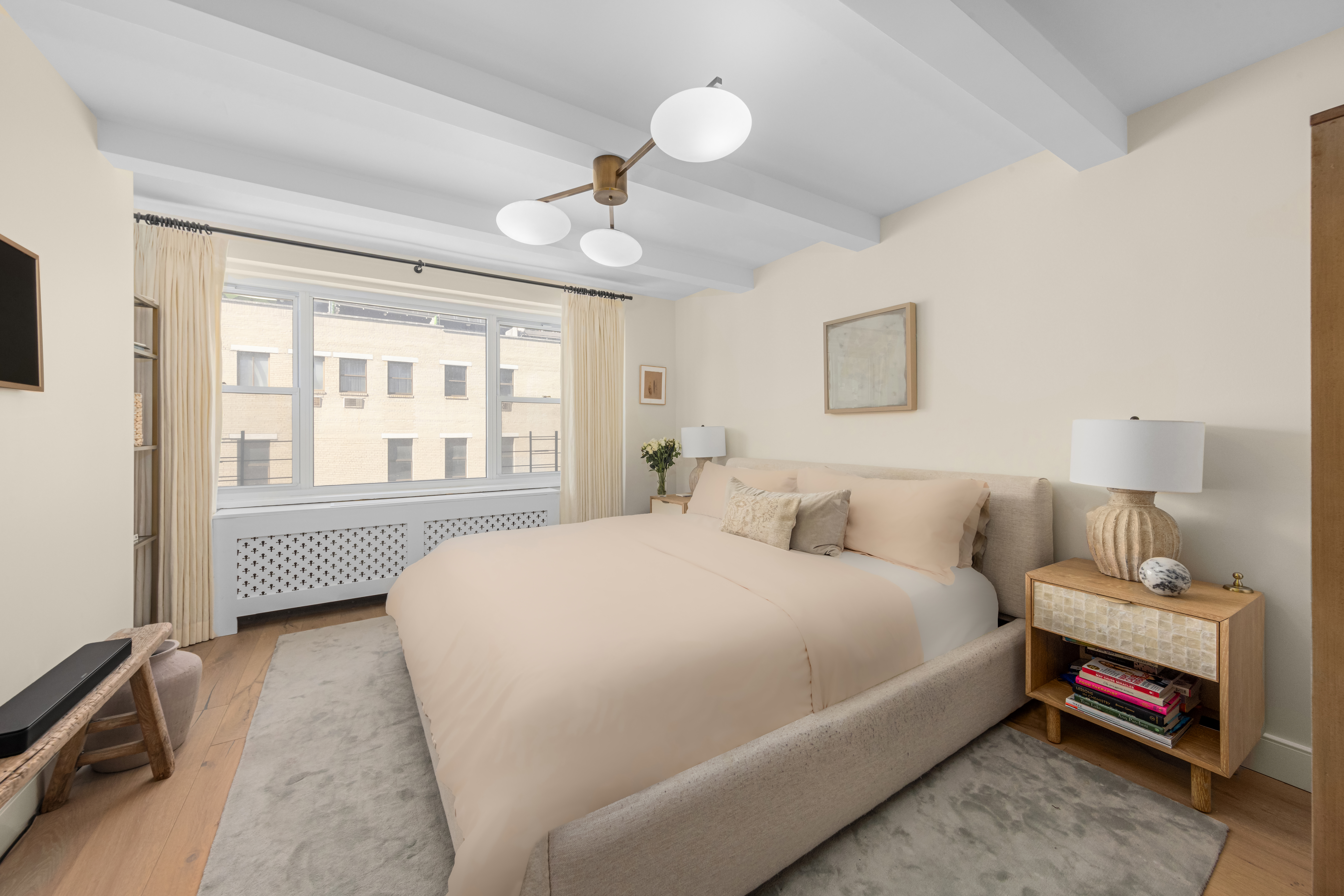 135 East 83rd Street, Unit 8/9C Manhattan, NY 10028 - Photo 11 of 15 a bedroom with a bed chandelier and a window