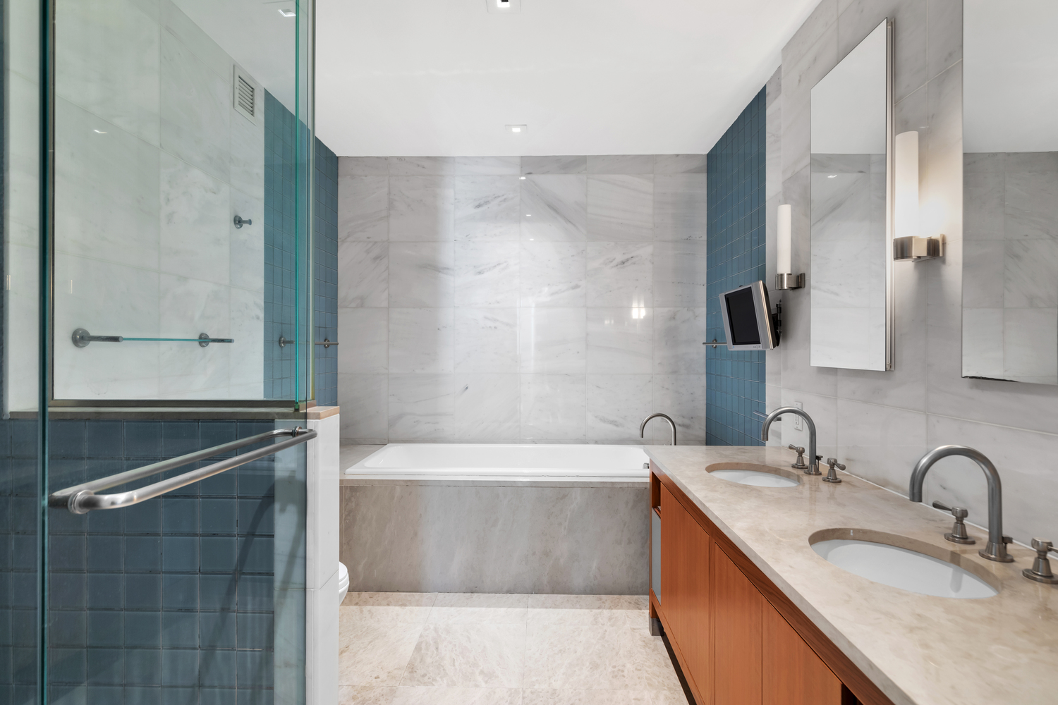 300 East 55th Street, Unit 28B Manhattan, NY 10022 - Photo 5 of 12 a bathroom with a granite countertop sink a bathtub and mirror