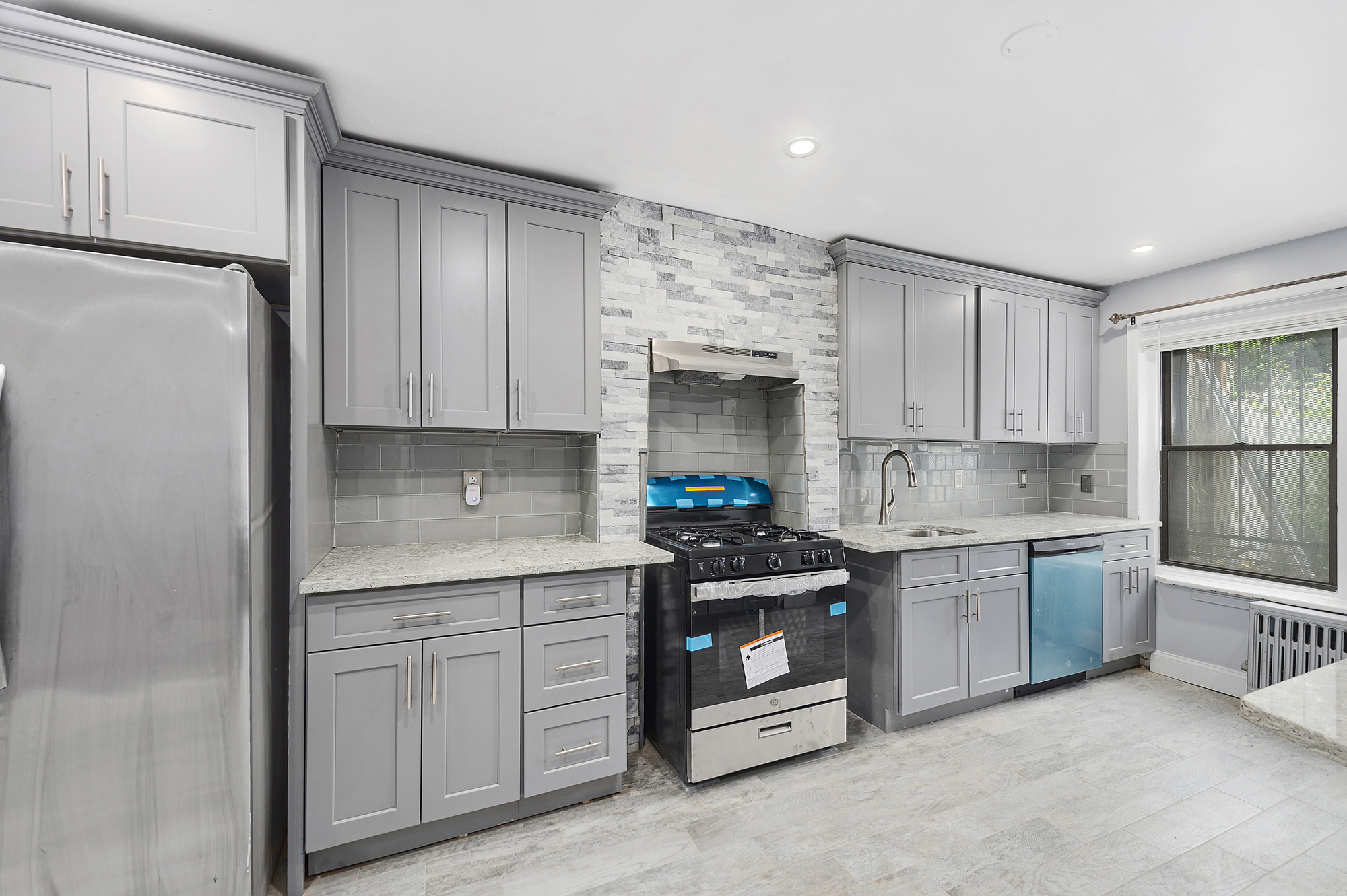 194 Pulaski Street, Unit 1 Brooklyn, NY 11206 - Photo 1 of 6 a kitchen with stainless steel appliances granite countertop a refrigerator sink and stove