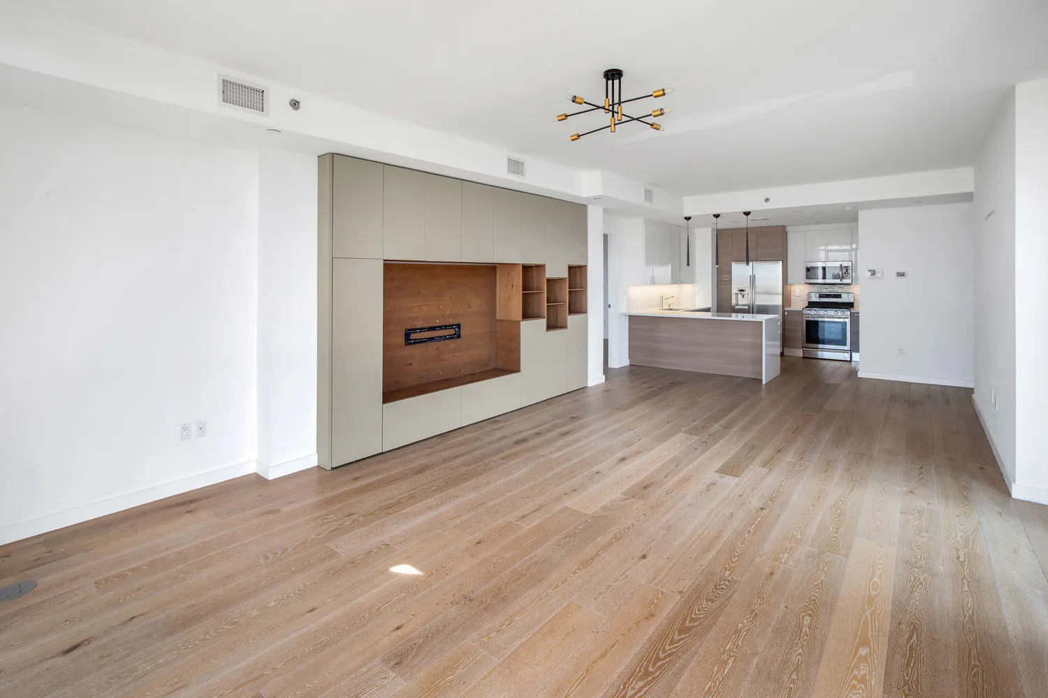 a view of empty room with wooden floor and window
