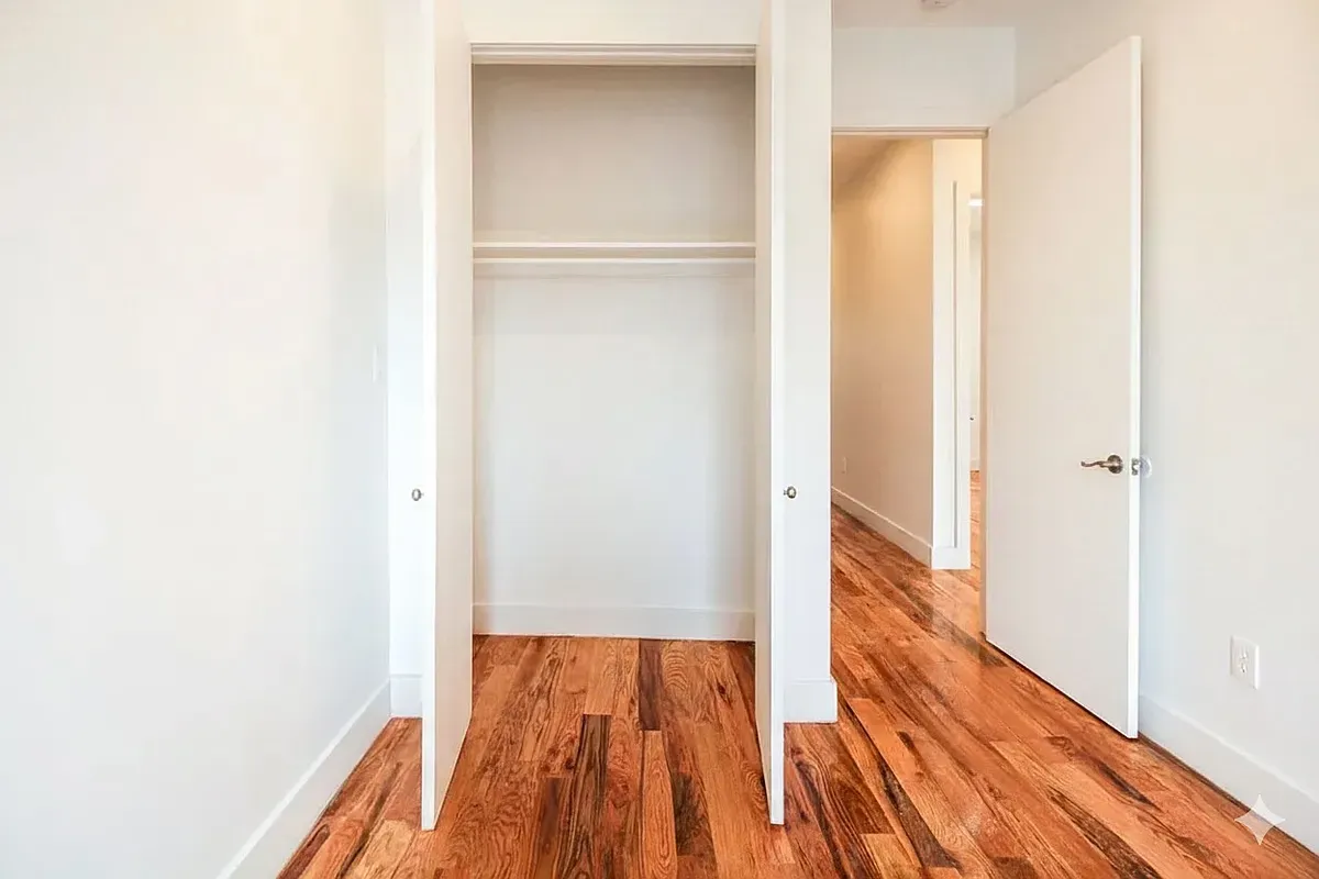 a view of a room with wooden floor and a bathroom