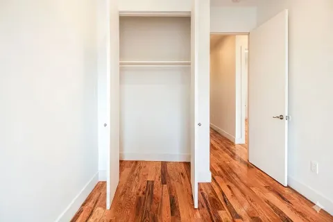 a view of a room with wooden floor and a bathroom
