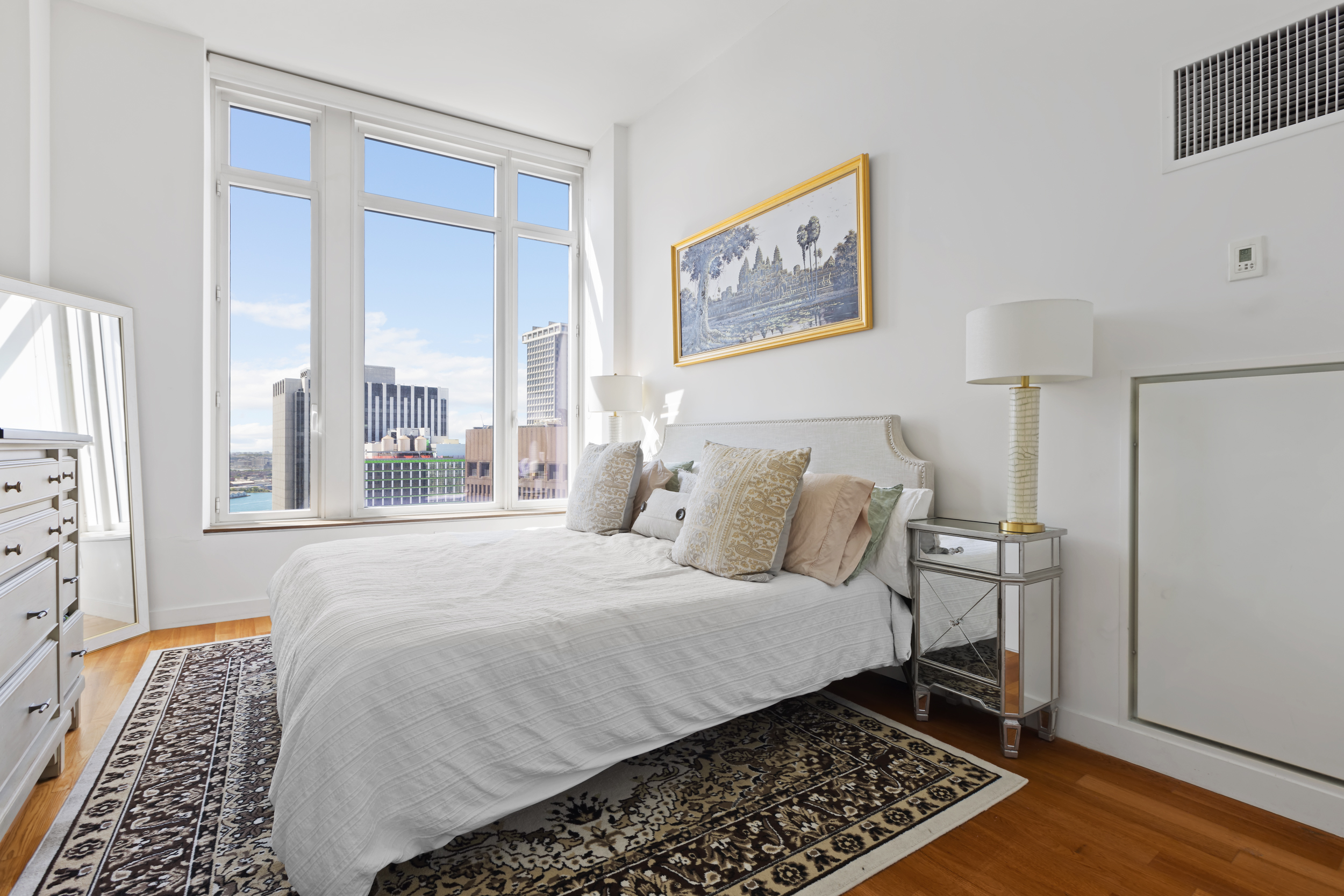 15 William Street, Unit 40C Manhattan, NY 10005 - Photo 5 of 18 a bedroom with a bed and a window with chair