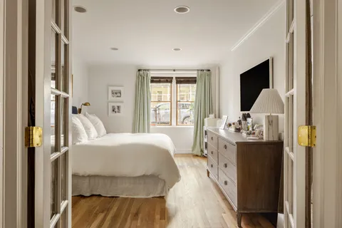 a bedroom with a bed and a large window