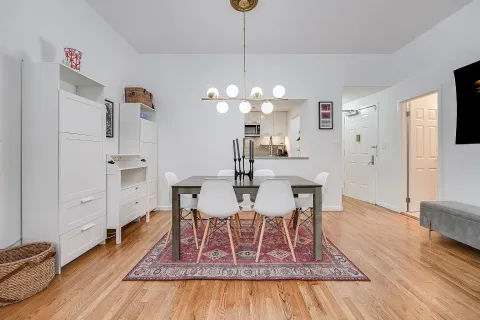 a dining room with wooden floor a chandelier a wooden table and chairs