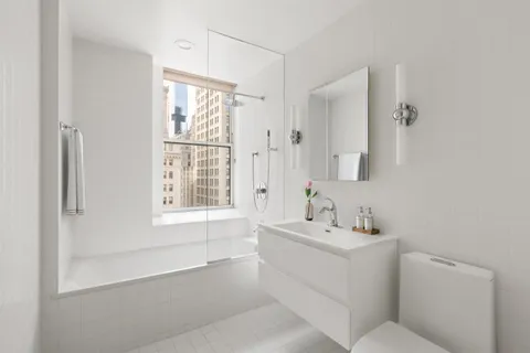 a bathroom with a sink toilet vanity and tub