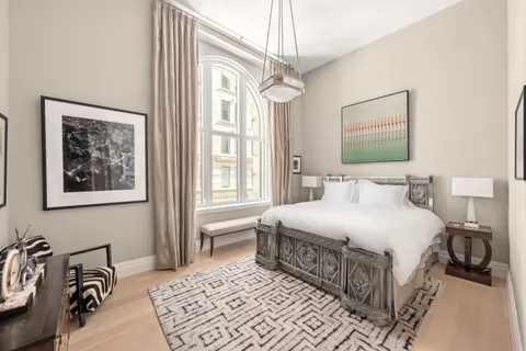 a bedroom with a bed a mirror and a window
