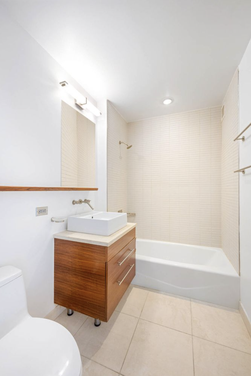 225 West 60th Street, Unit 8F Manhattan, NY 10023 - Photo 7 of 11 a bathroom with a sink a toilet and bathtub