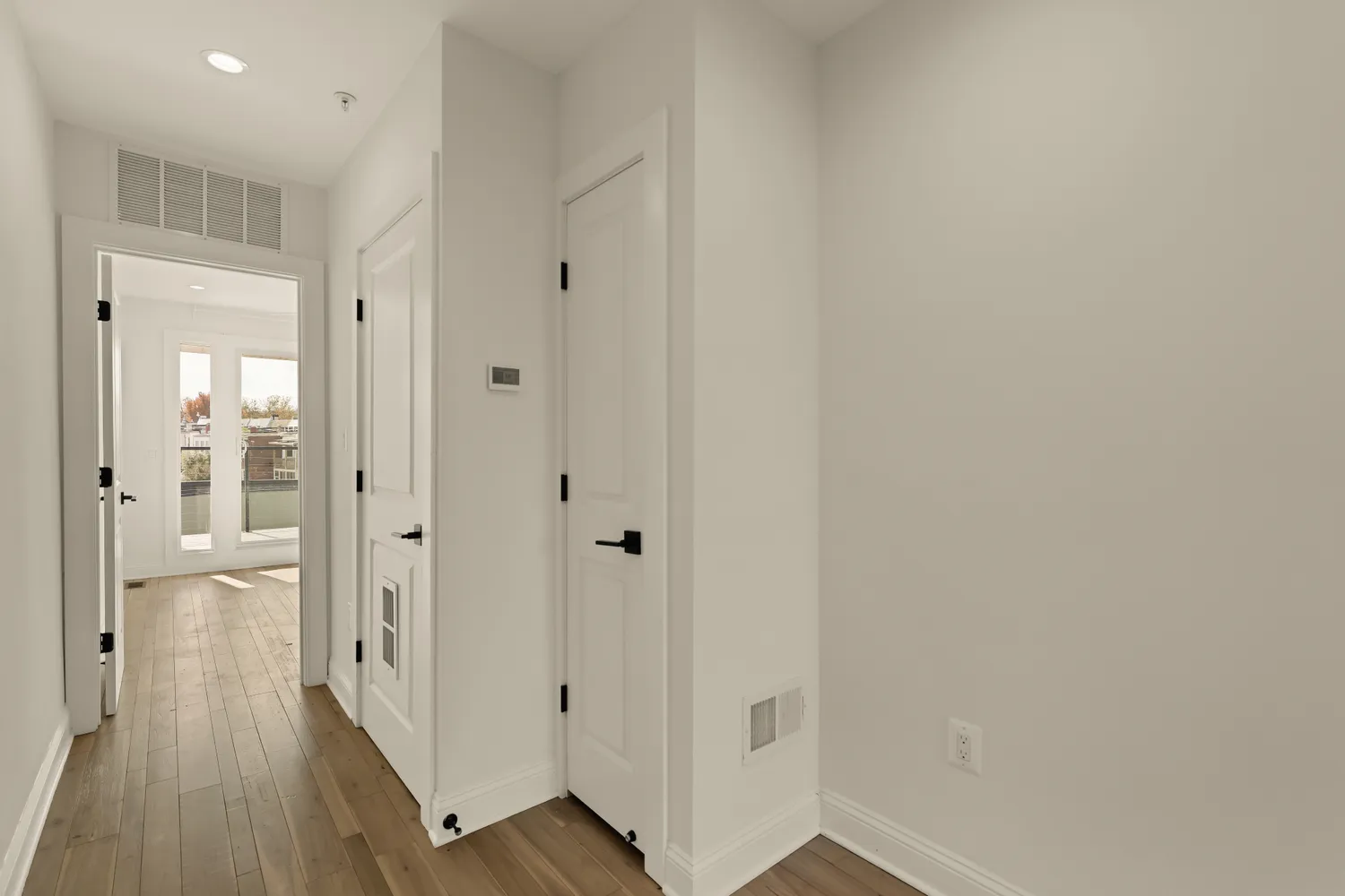 a view of a hallway with wooden floor