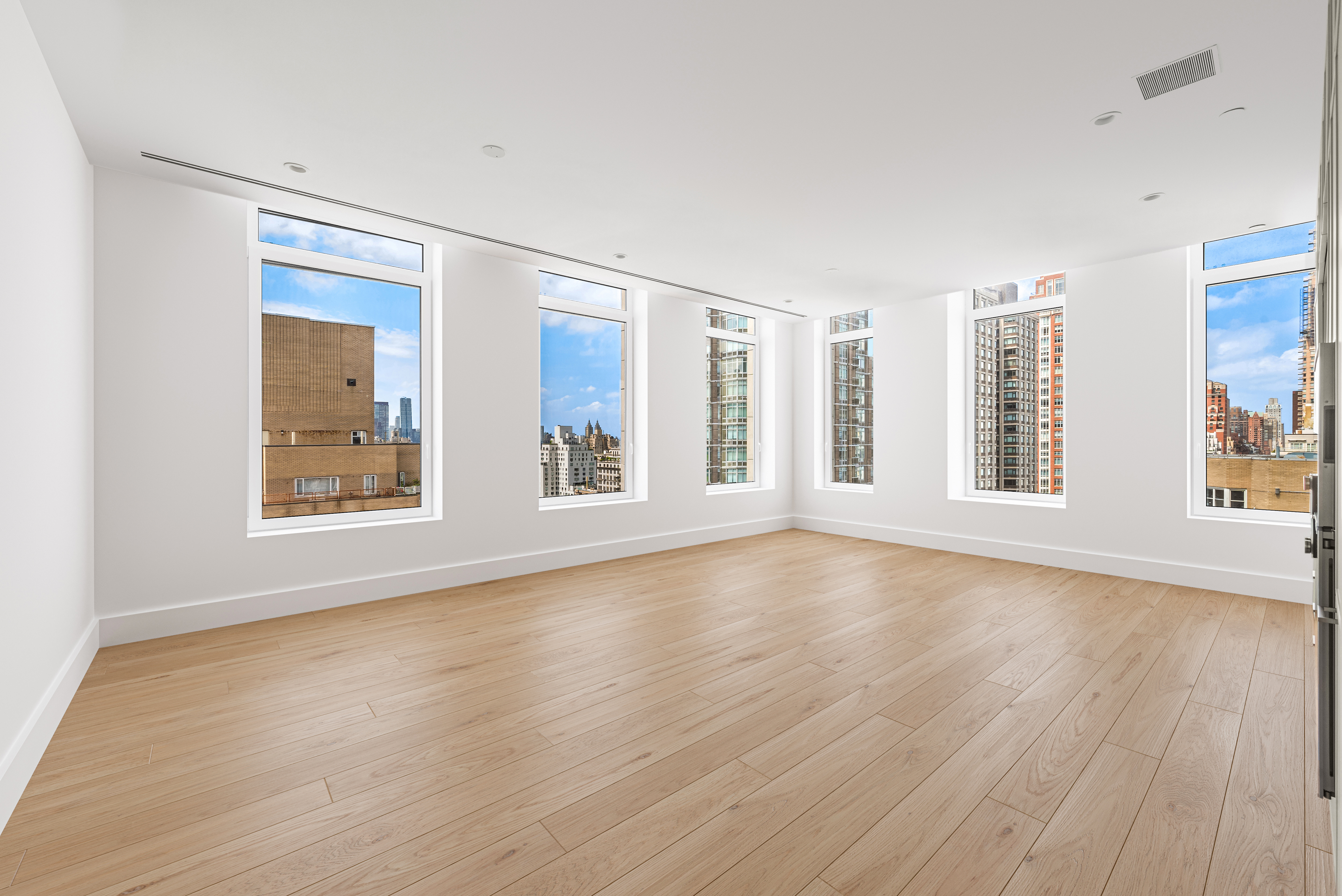 1059 3rd Avenue, Unit 18B Manhattan, NY 10065 - Photo 2 of 11 a view of an empty room with wooden floor and a window