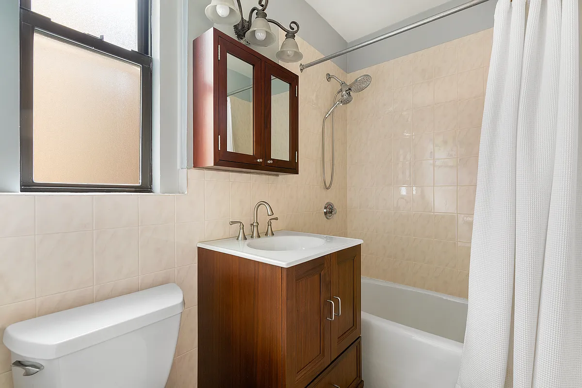 675 West End Avenue, Unit 4C Manhattan, NY 10025 - Photo 6 of 10 a bathroom with a granite countertop sink toilet a mirror and shower