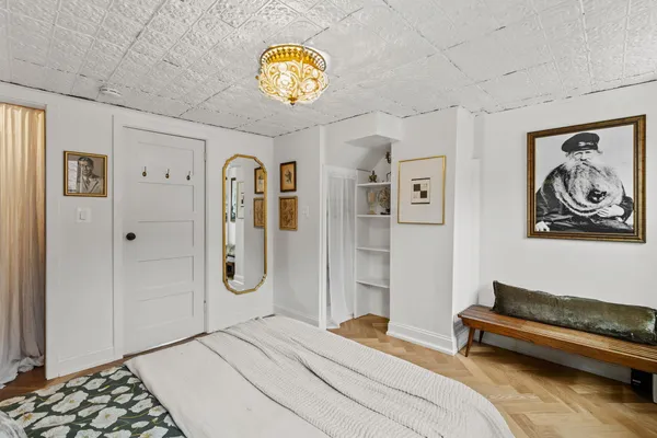 a bedroom with a bed and painting on the wall