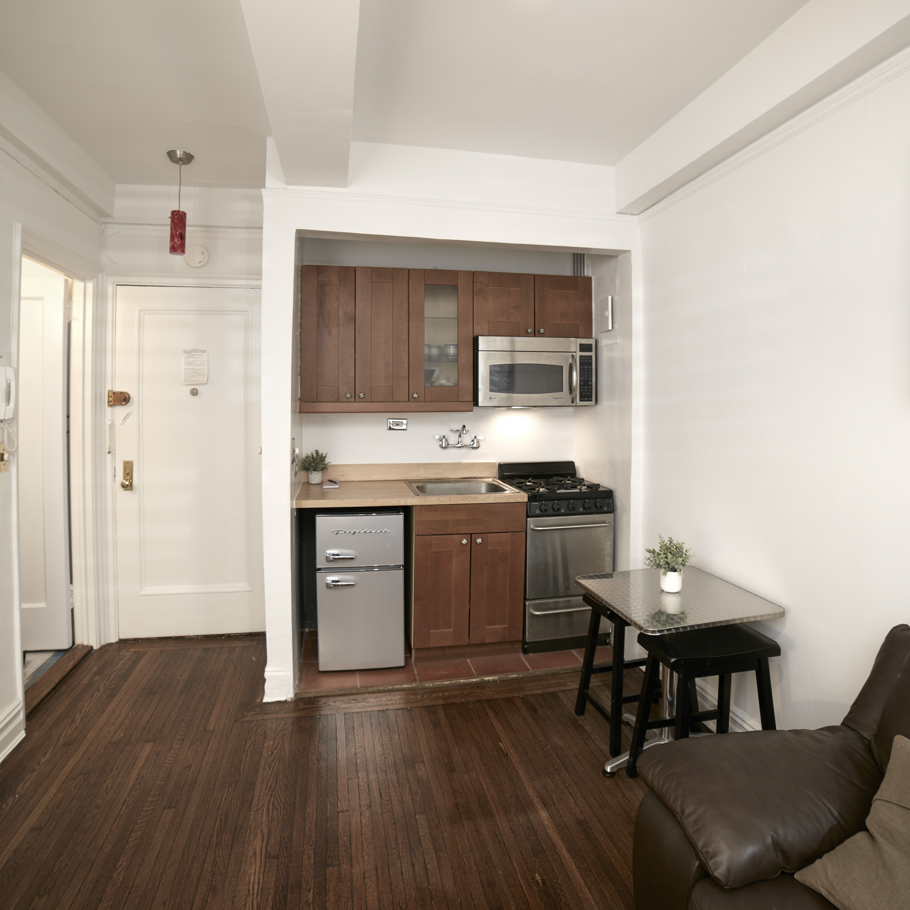 457 West 57th Street, Unit 108 Manhattan, NY 10019 - Photo 2 of 8 a kitchen with a sink cabinets and wooden floor