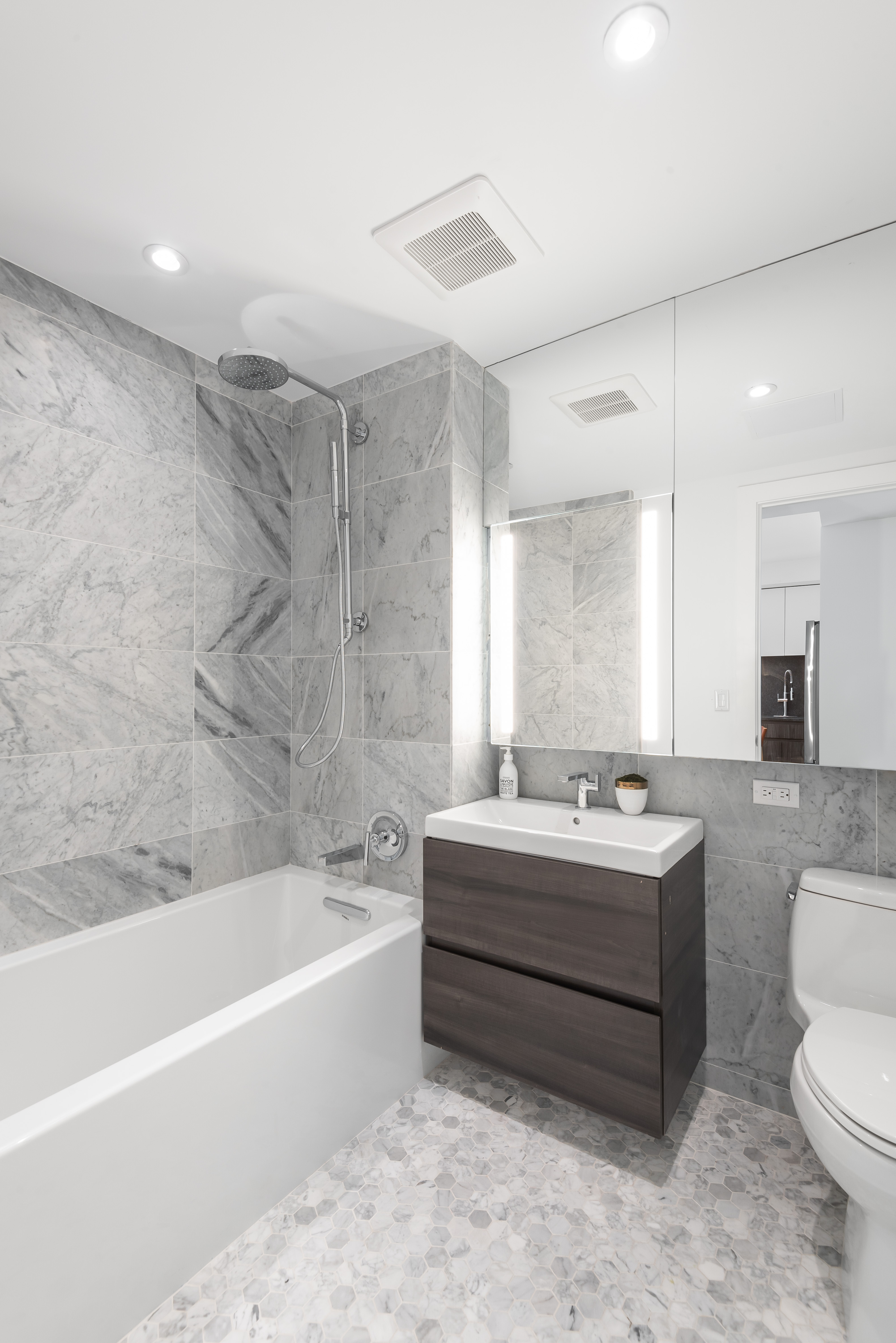 435 Tompkins Avenue, Unit 304S Brooklyn, NY 11216 - Photo 6 of 15 a bathroom with a bathtub toilet sink mirror and vanity