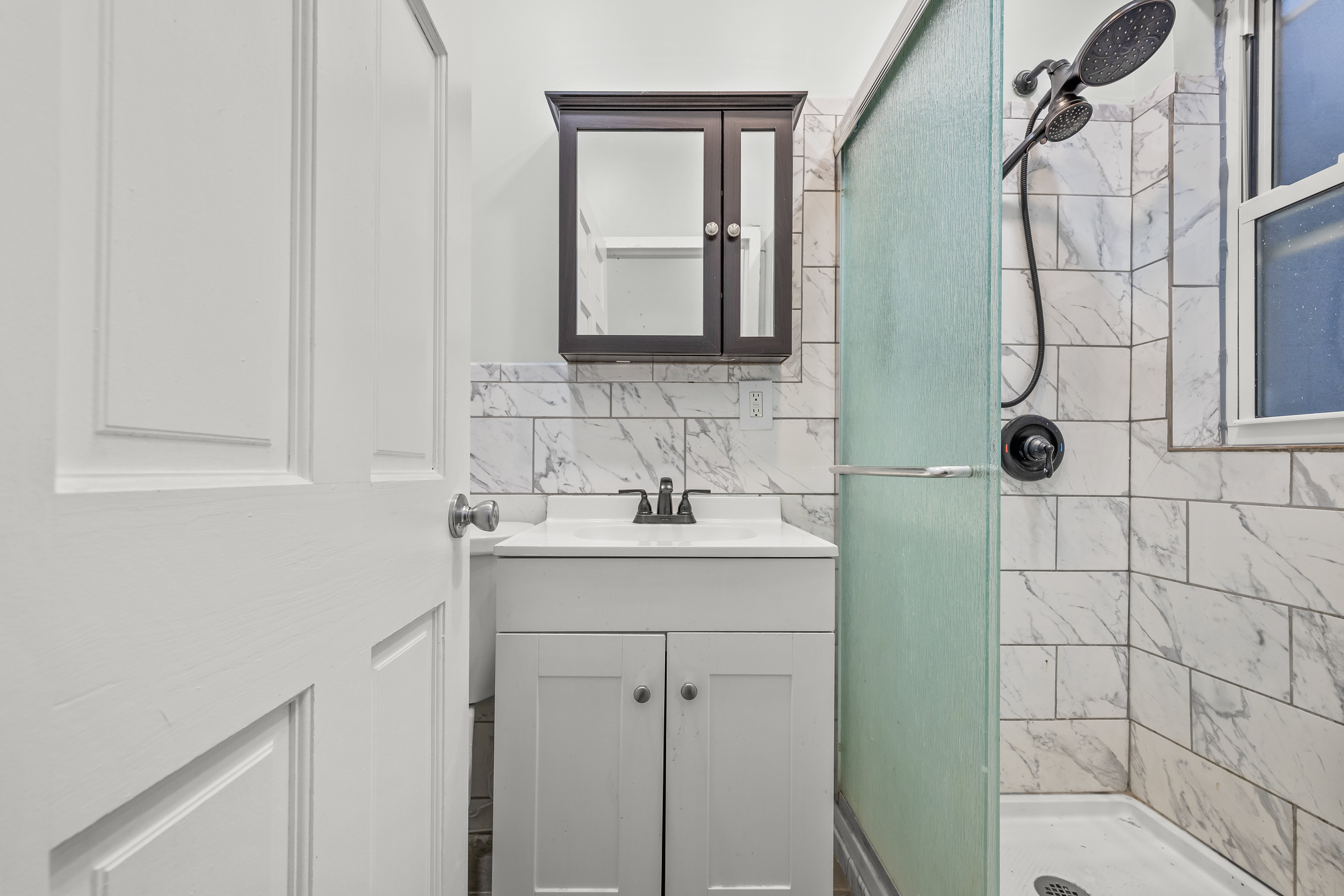 2023 Hughes Avenue Bronx, NY 10457 - Photo 14 of 63 a bathroom with a granite countertop sink a toilet and a mirror