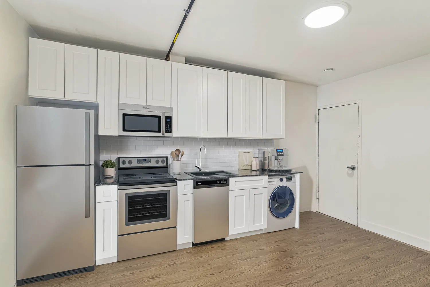 a kitchen with stainless steel appliances granite countertop a stove a refrigerator and a white cabinets