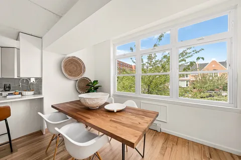a dining room with wooden floor and a window