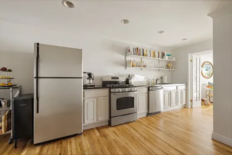 a kitchen with stainless steel appliances granite countertop a refrigerator and a stove top oven