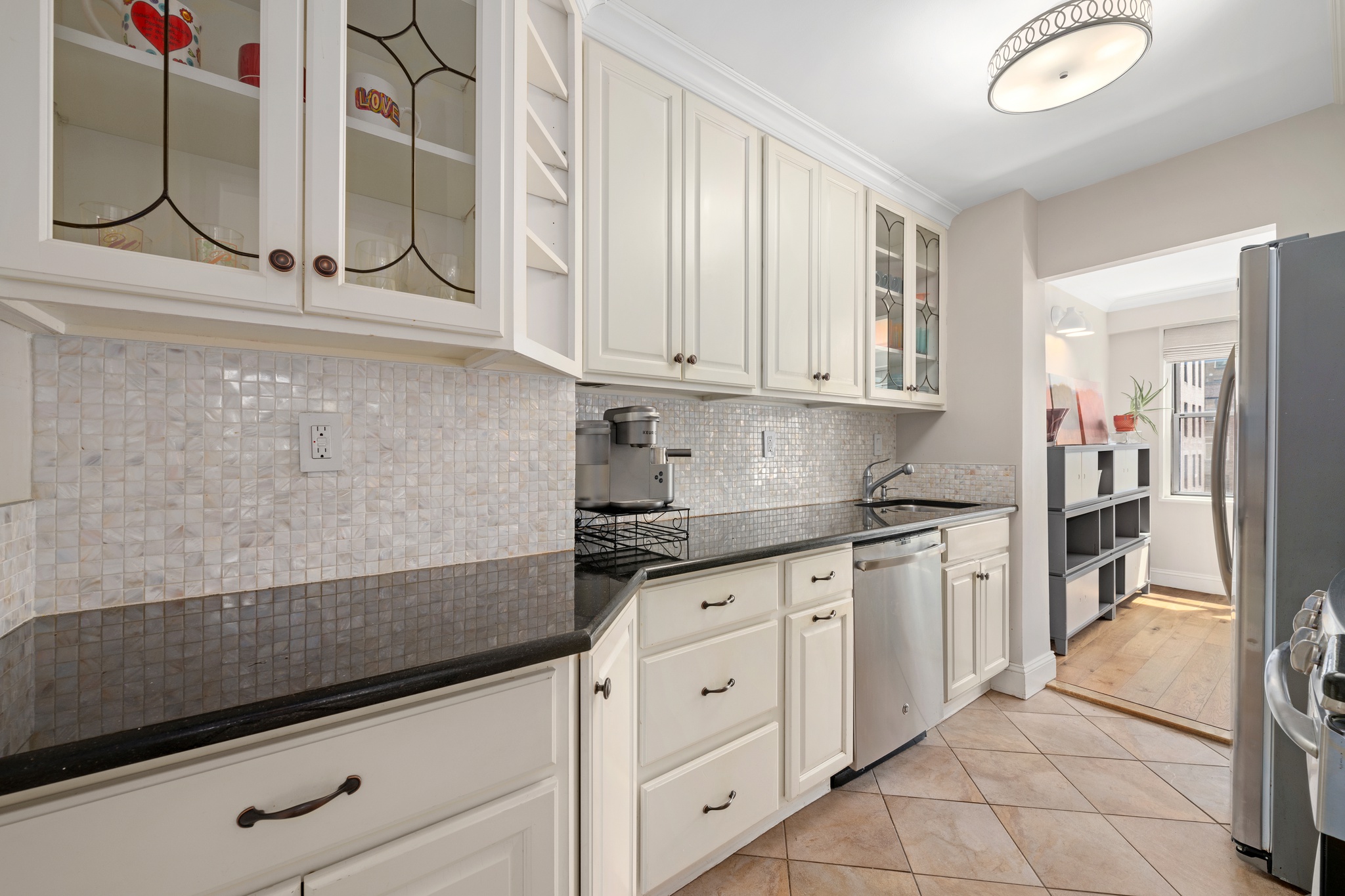 10 West 15th Street, Unit 1027/1028 Manhattan, NY 10011 - Photo 4 of 15 a kitchen with granite countertop white cabinets and white appliances