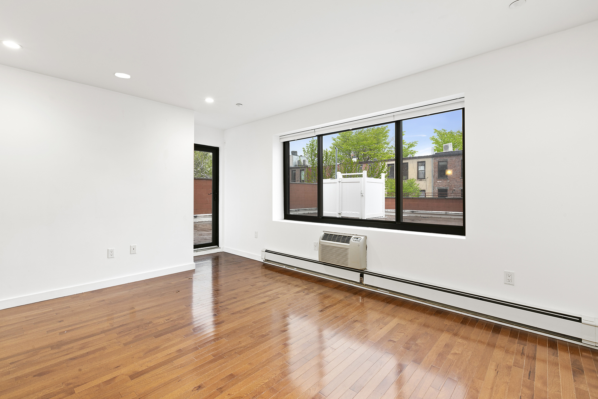 400 15th Street, Unit 2D Brooklyn, NY 11215 - Photo 2 of 8 an empty room with wooden floor and windows