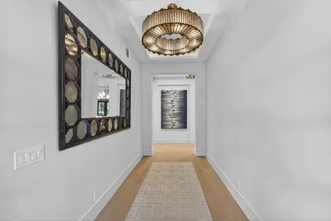 a view of a hallway with wooden floor and a dining room