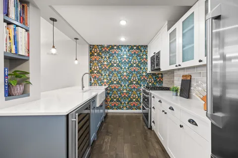 a kitchen with stainless steel appliances a stove and a wooden floor