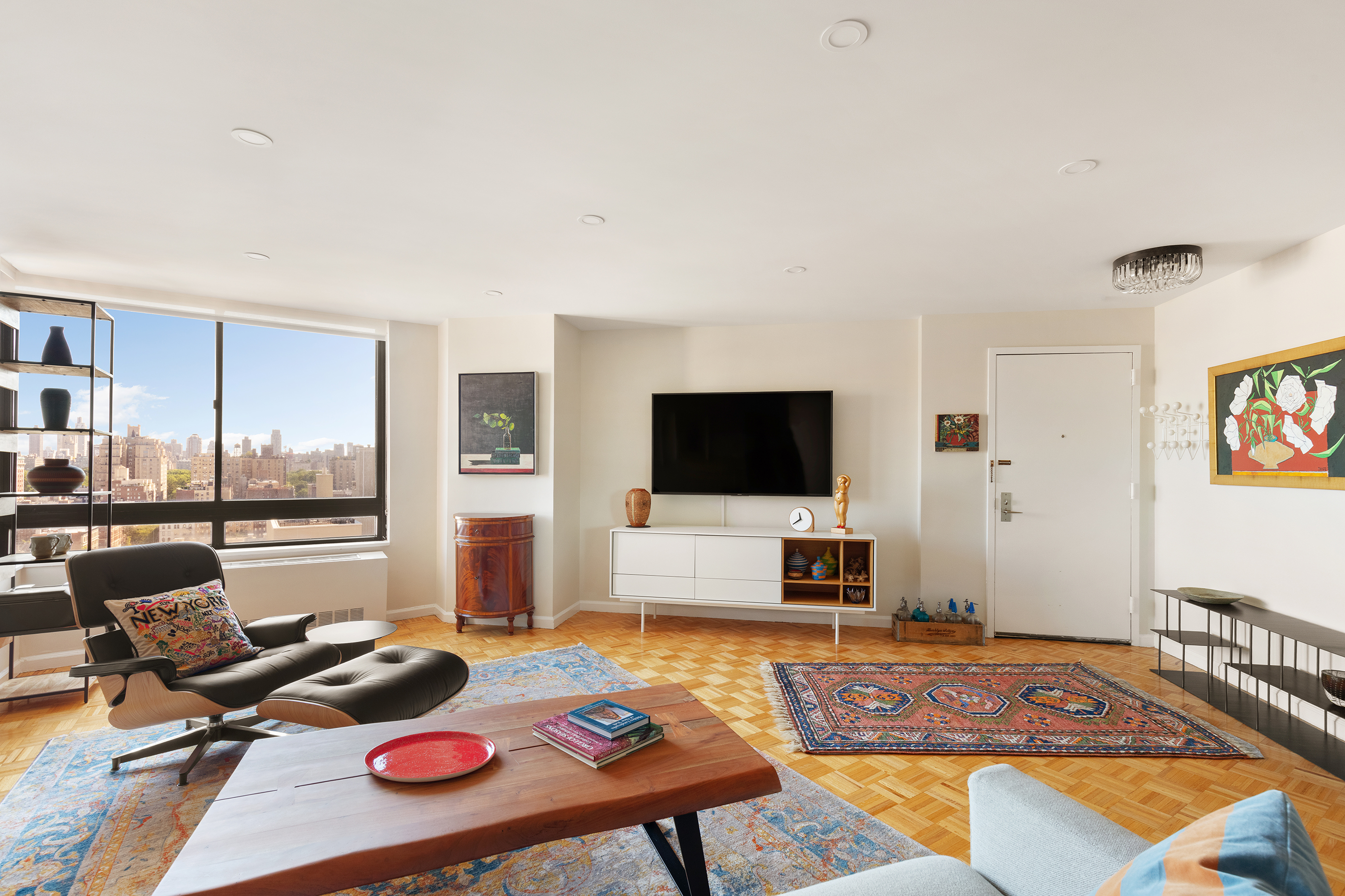225 West 83rd Street, Unit 19A Manhattan, NY 10024 - Photo 2 of 15 a bedroom with furniture and a flat screen tv