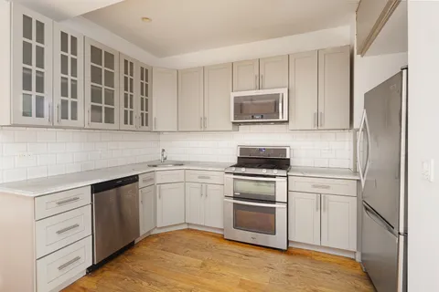 a kitchen with cabinets stainless steel appliances and a sink
