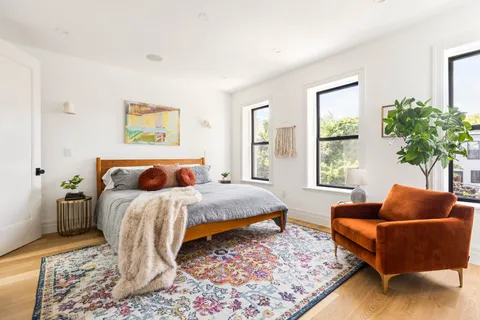 a bedroom with bed couch and window