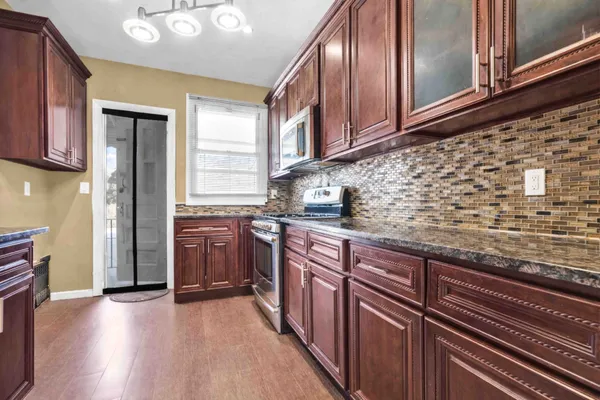 a kitchen with stainless steel appliances granite countertop a refrigerator and a stove top oven