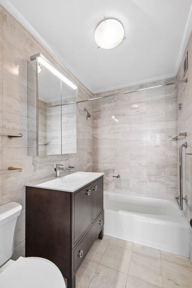 40 East 80th Street, Unit 25A Manhattan, NY 10075 - Photo 15 of 18 a bathroom with a sink toilet double vanity and bathtub