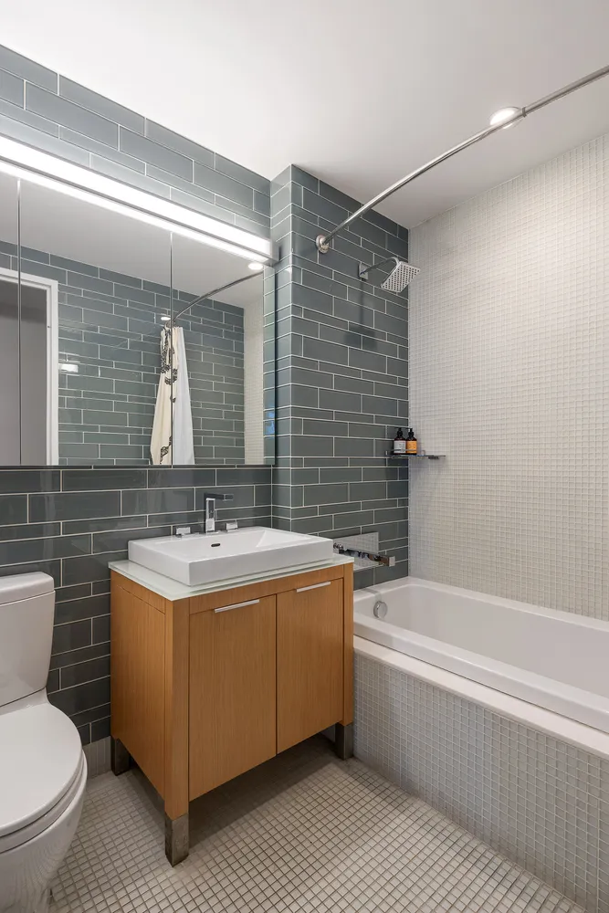 a bathroom with a sink mirror vanity bathtub and a toilet