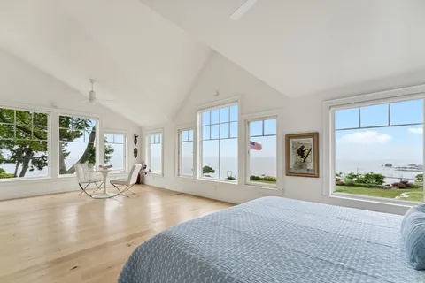 a spacious bedroom with a large window and a table