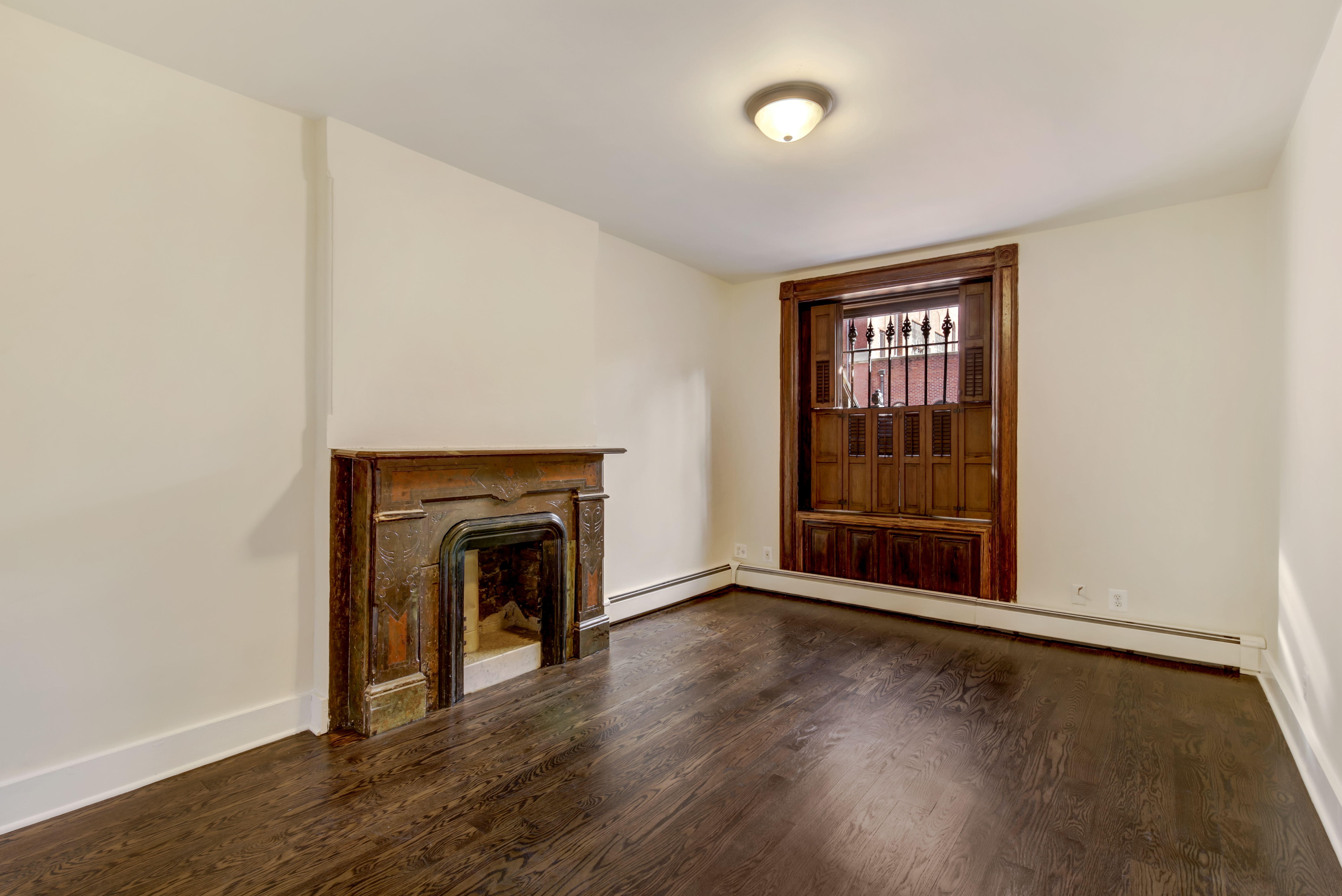 67 Gates Avenue, Unit 1 Brooklyn, NY 11238 - Photo 6 of 7 an empty room with wooden floor fireplace and windows