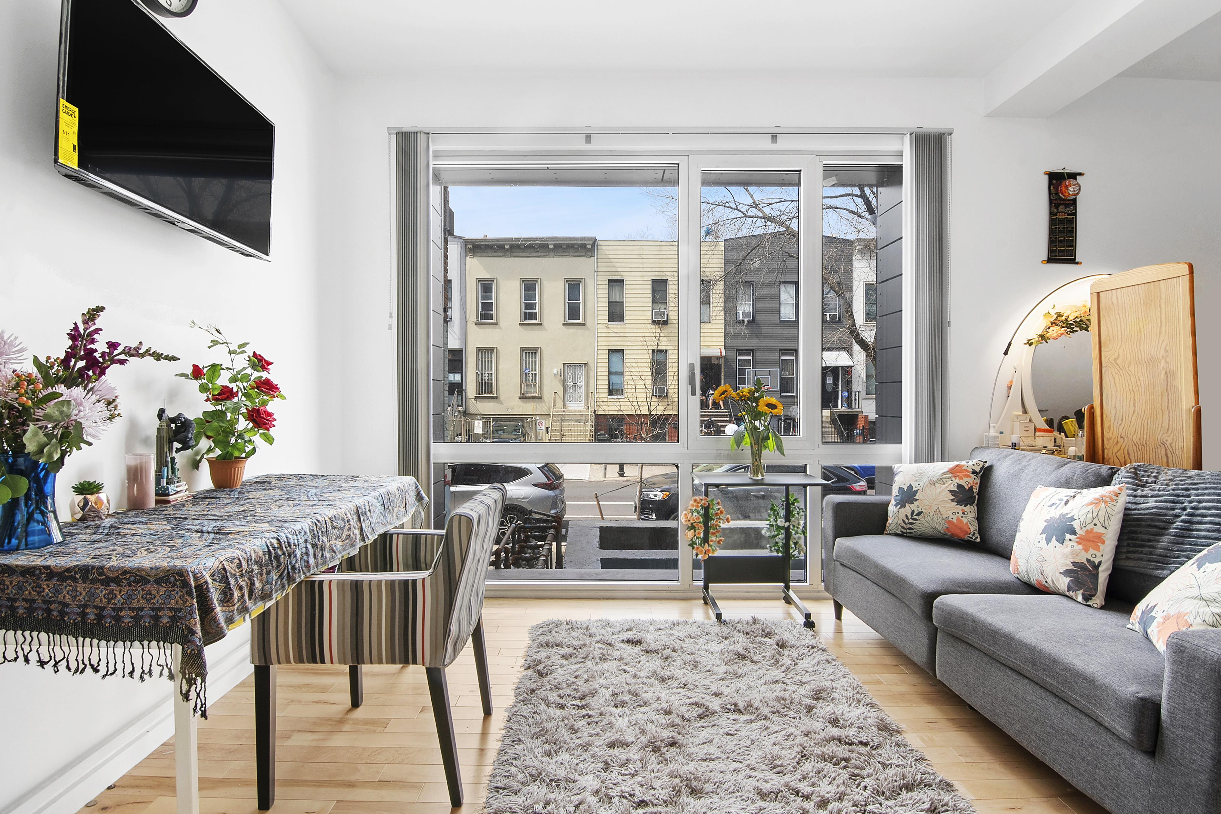1064 Hancock Street, Unit 101 Brooklyn, NY 11221 - Photo 1 of 9 a living room with furniture and a flat screen tv