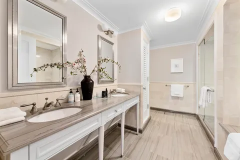 a en suite bathroom with a granite countertop sink and a mirror