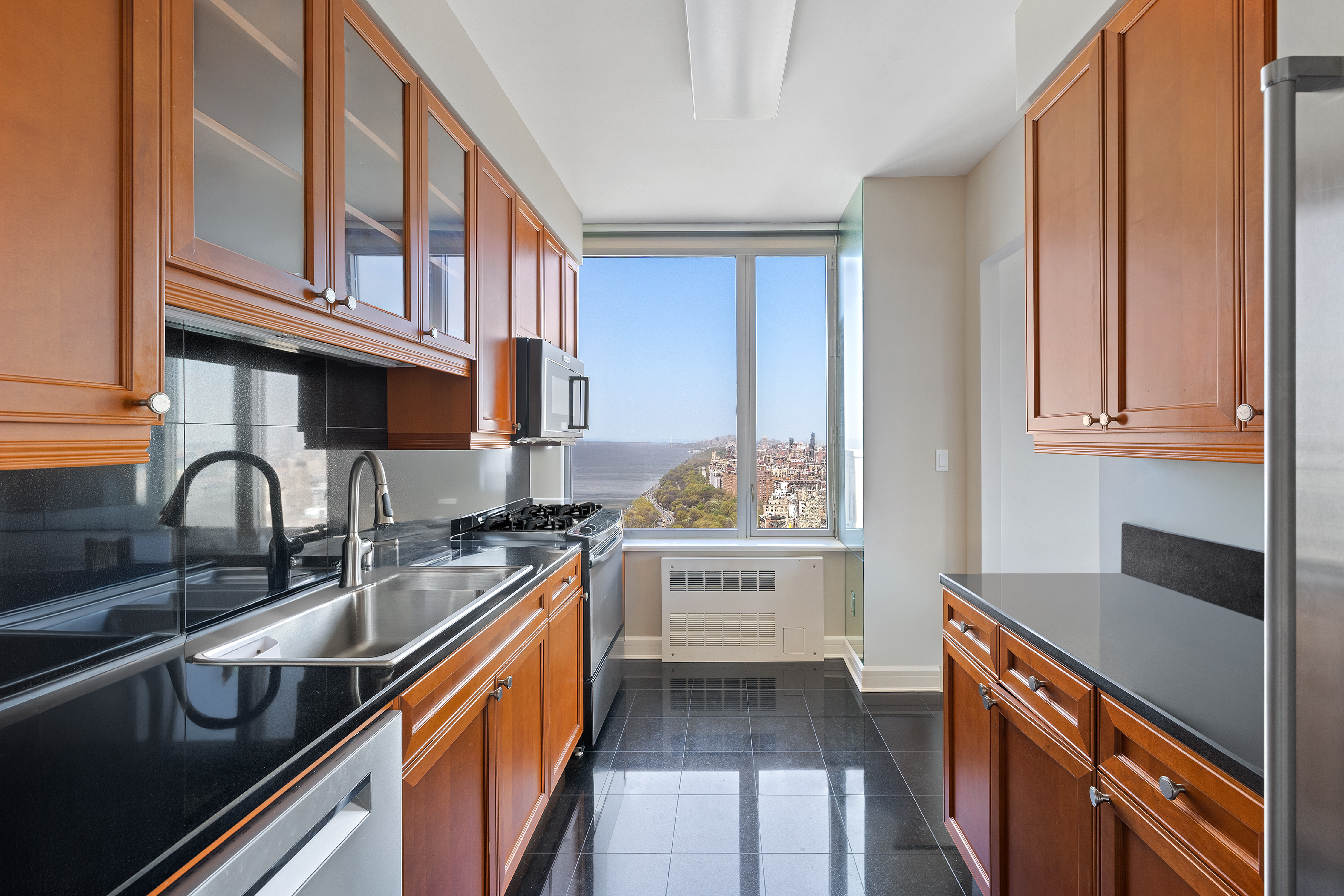 220 Riverside Boulevard, Unit 39B Manhattan, NY 10069 - Photo 6 of 16 a kitchen with stainless steel appliances granite countertop a sink stove and cabinets