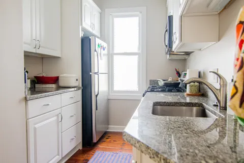 a kitchen with white cabinets and a sink