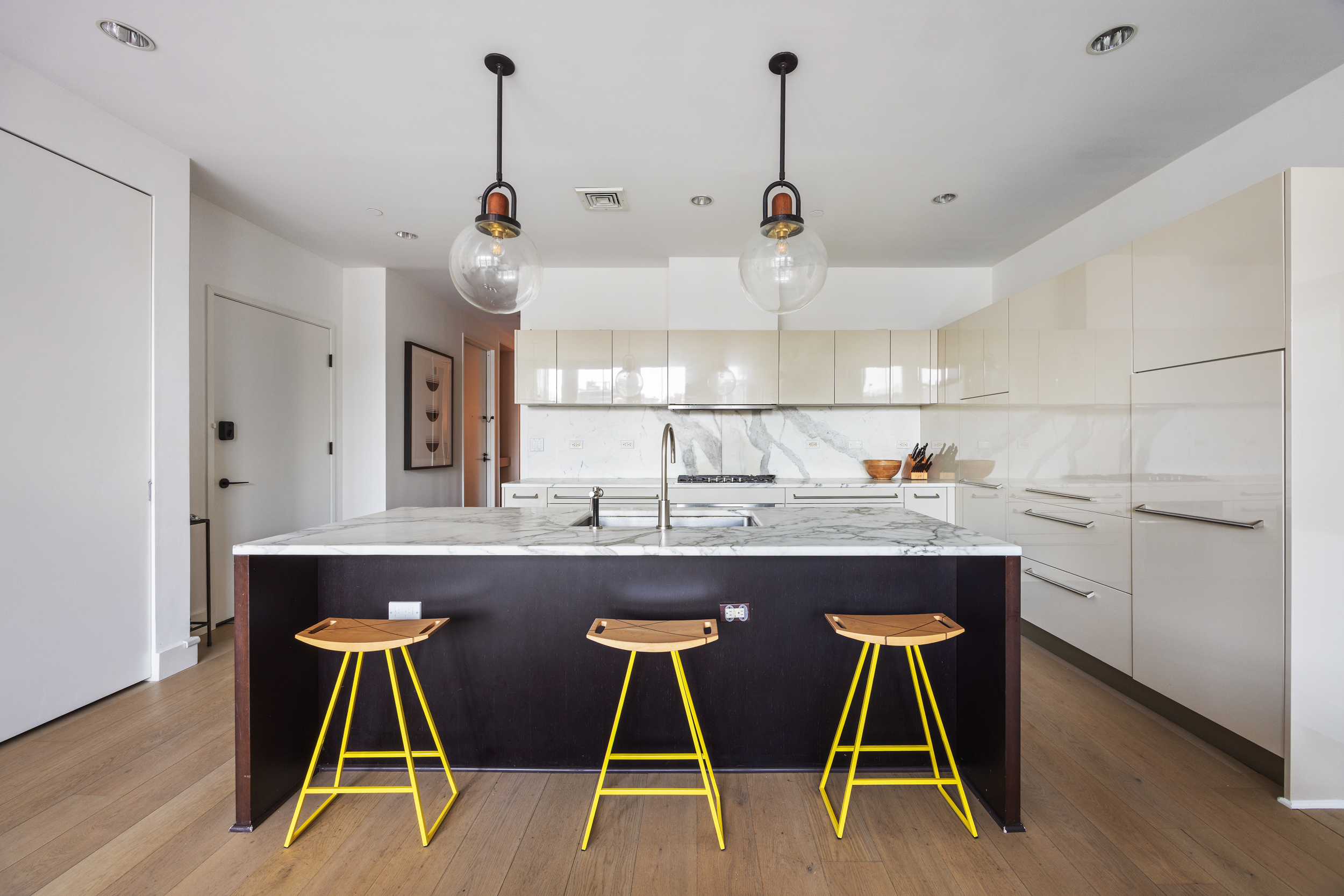 51 Walker Street, Unit 8B Manhattan, NY 10013 - Photo 6 of 16 a kitchen with kitchen island stainless steel appliances a dining table chairs sink and cabinets