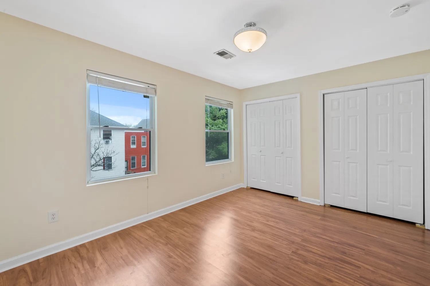 an empty room with wooden floor and closet