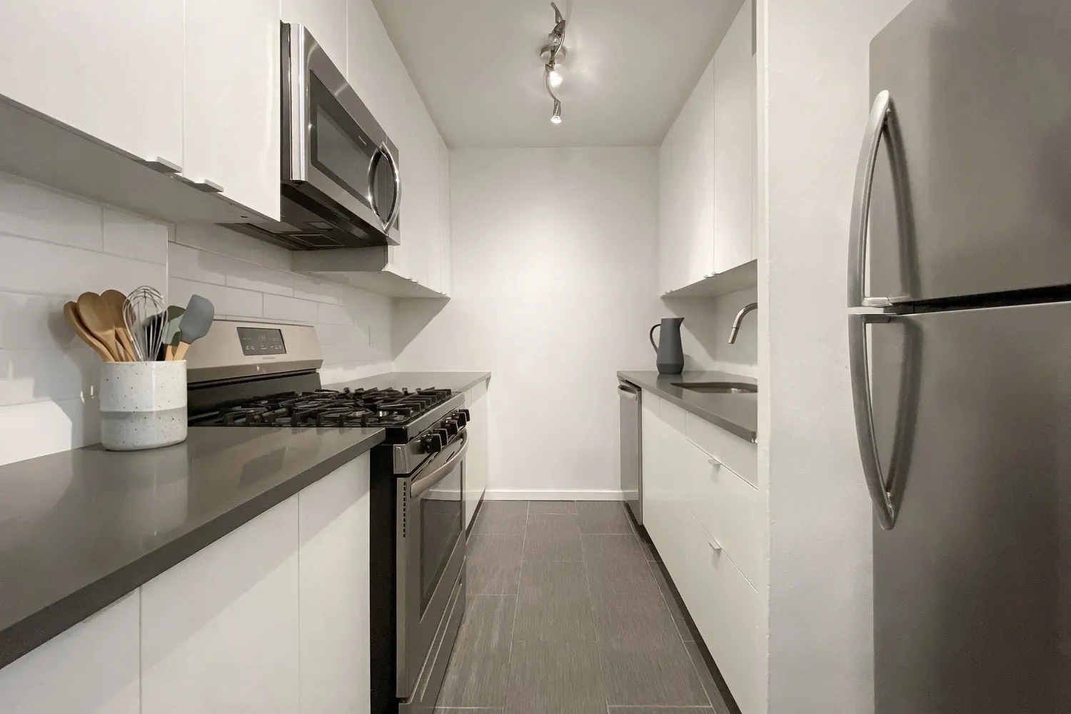 a kitchen with stainless steel appliances granite countertop a refrigerator and a stove